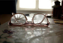 Foto von Brille mit einem gebrochenen und einem guten Glas